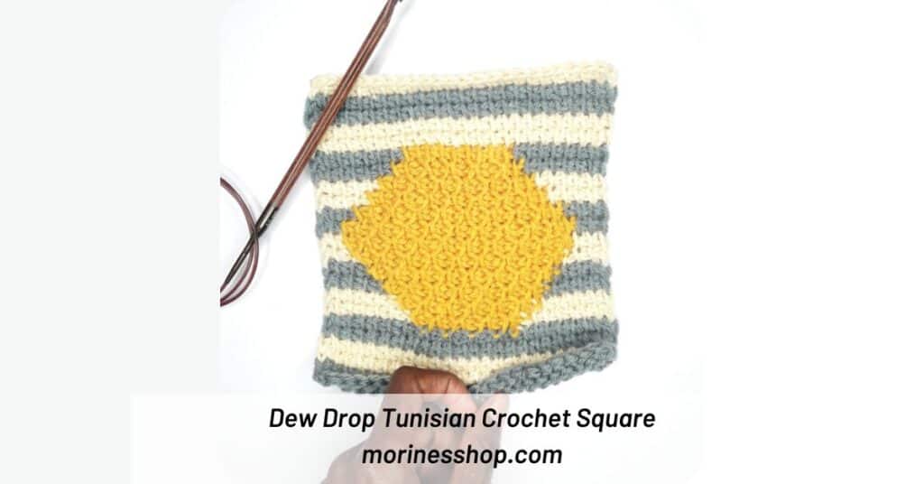 The Dew Drop Tunisian Crochet Square features a honeycomb hexagon in the middle with a striped contrasting background for a geometric design.